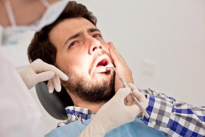 man at the emergency dentist in Marysville, WA because of tooth pain